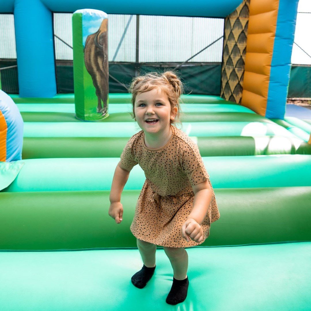 A little girl playing on the Tiny Tots bouncy castle at Woburn Safari Park